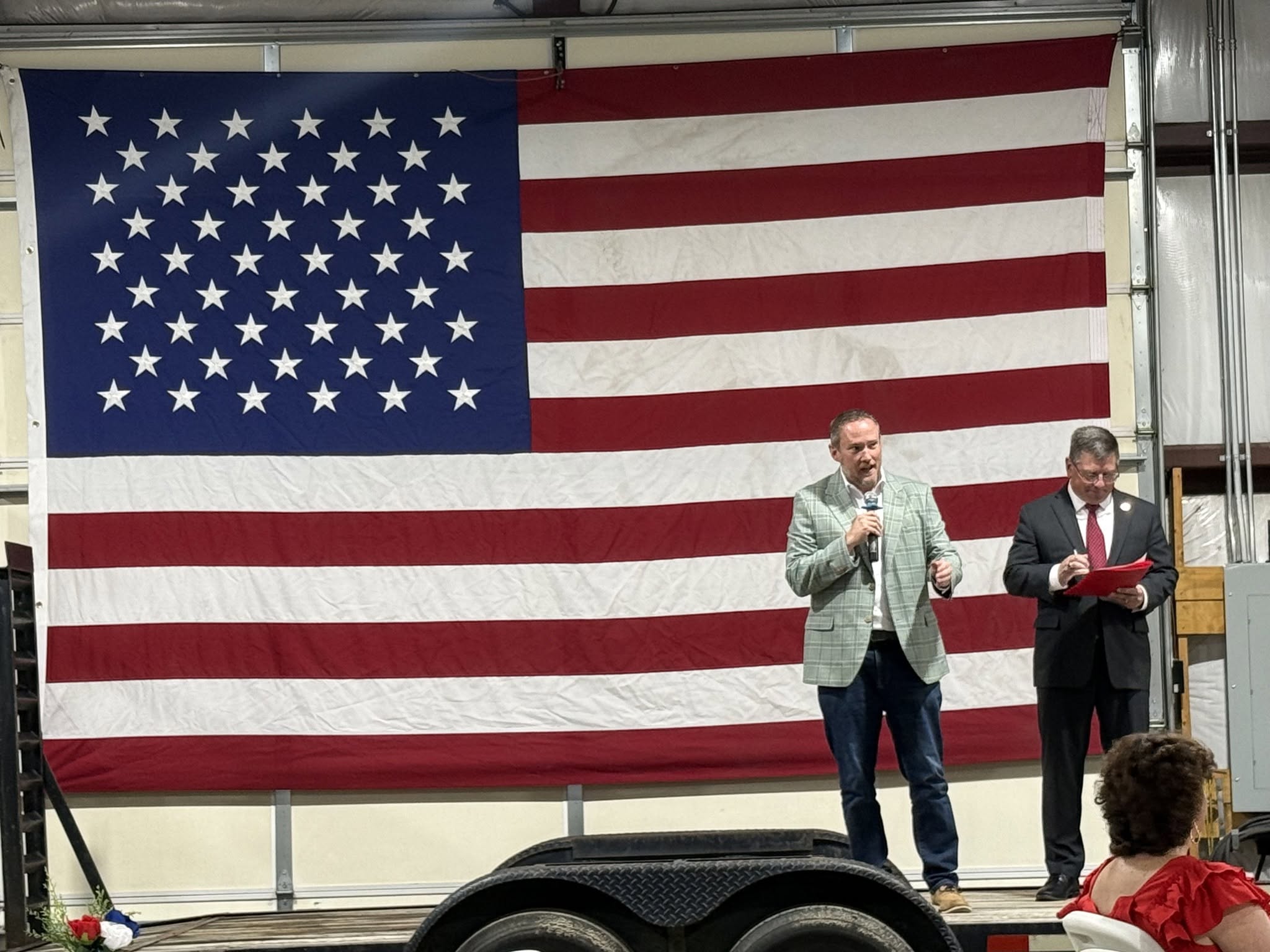 BJ Murphy speaking in front of an American flag